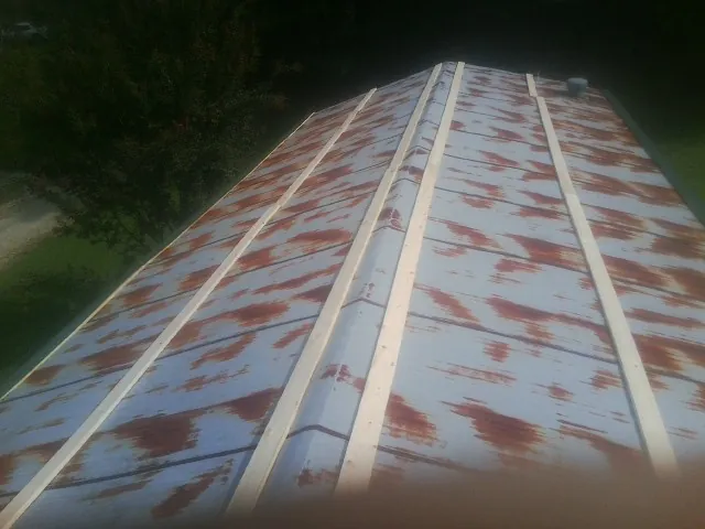 Rusted metal roof panels with new wood purlins before replacement — Storm Damage Roof Repair in Pearland by Roofing Brothers