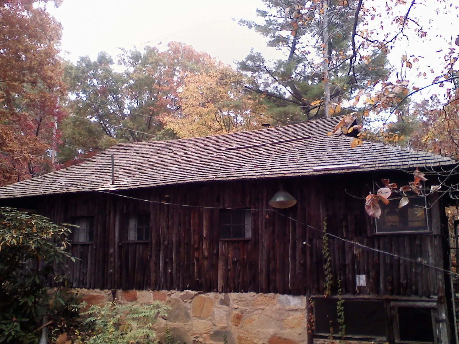 Weathered wood shake roof on a rustic board sided cabin in Pearland