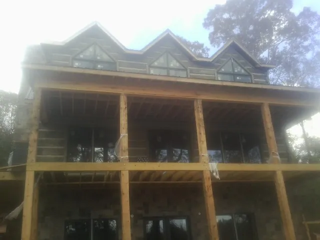 Dormers and porch framing on a large log home under construction — Roof Coating work by our crew in Pearland