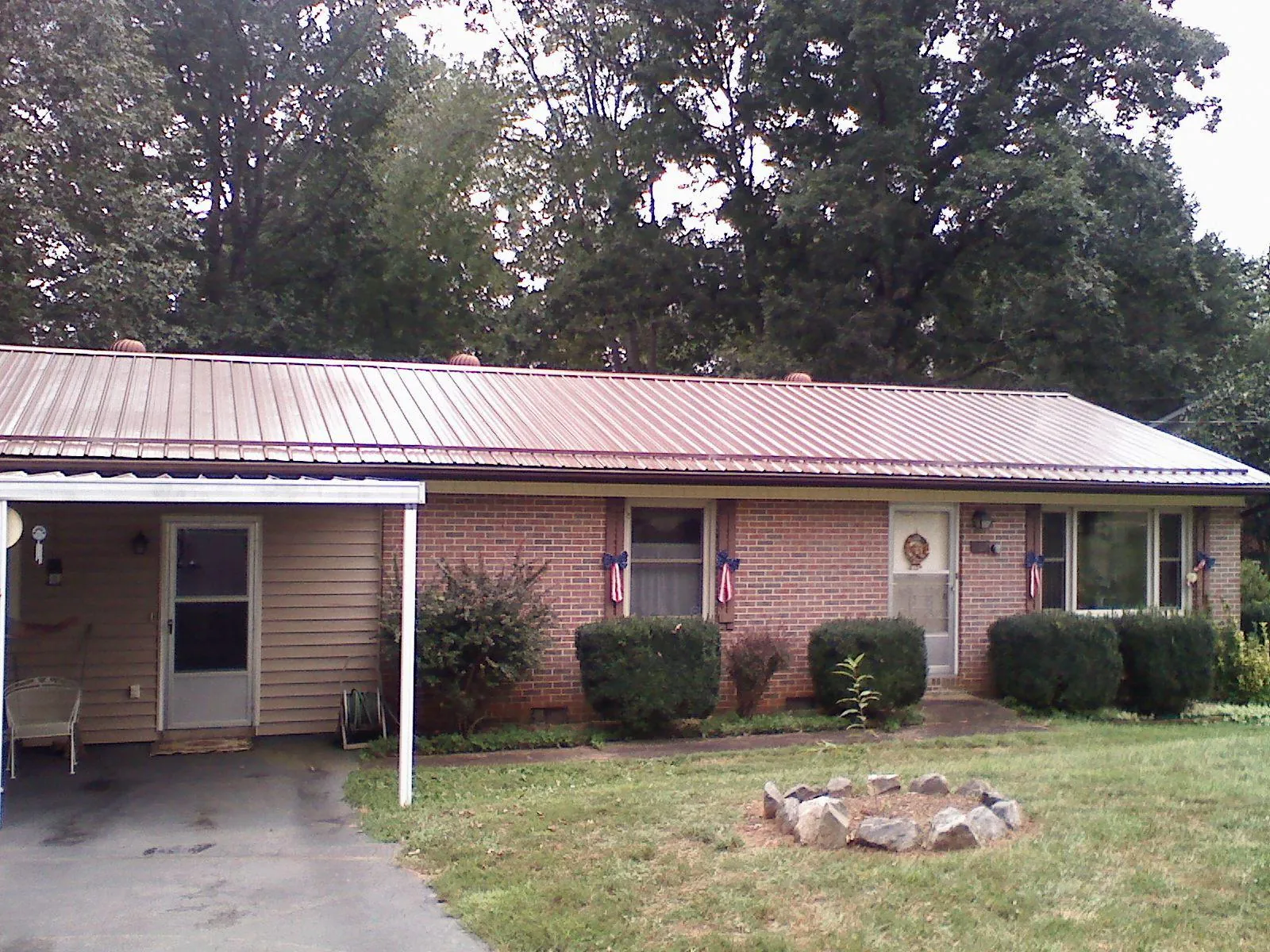 Bronze metal roof and carport on a brick ranch home — Roof Repair work by our crew in Pearland