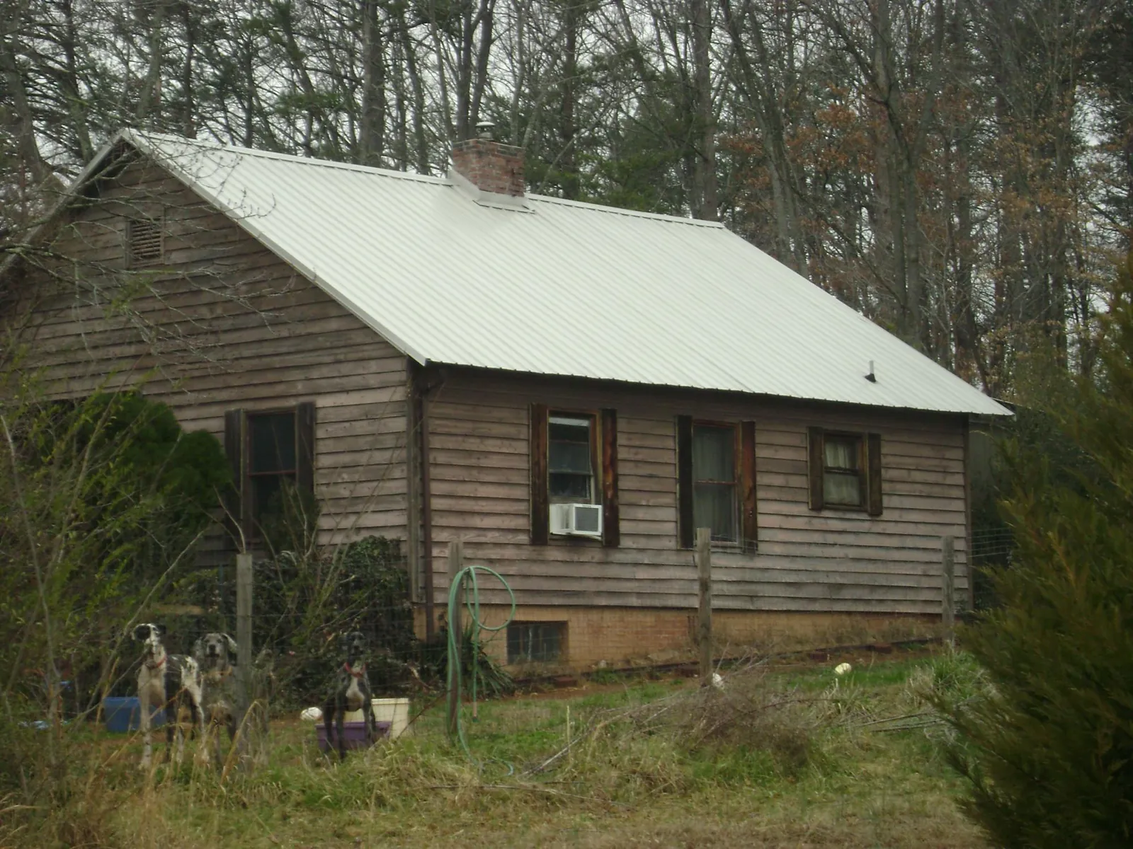 White metal roof on an old wood sided farmhouse, from a Metal Roof Installation job in Pearland